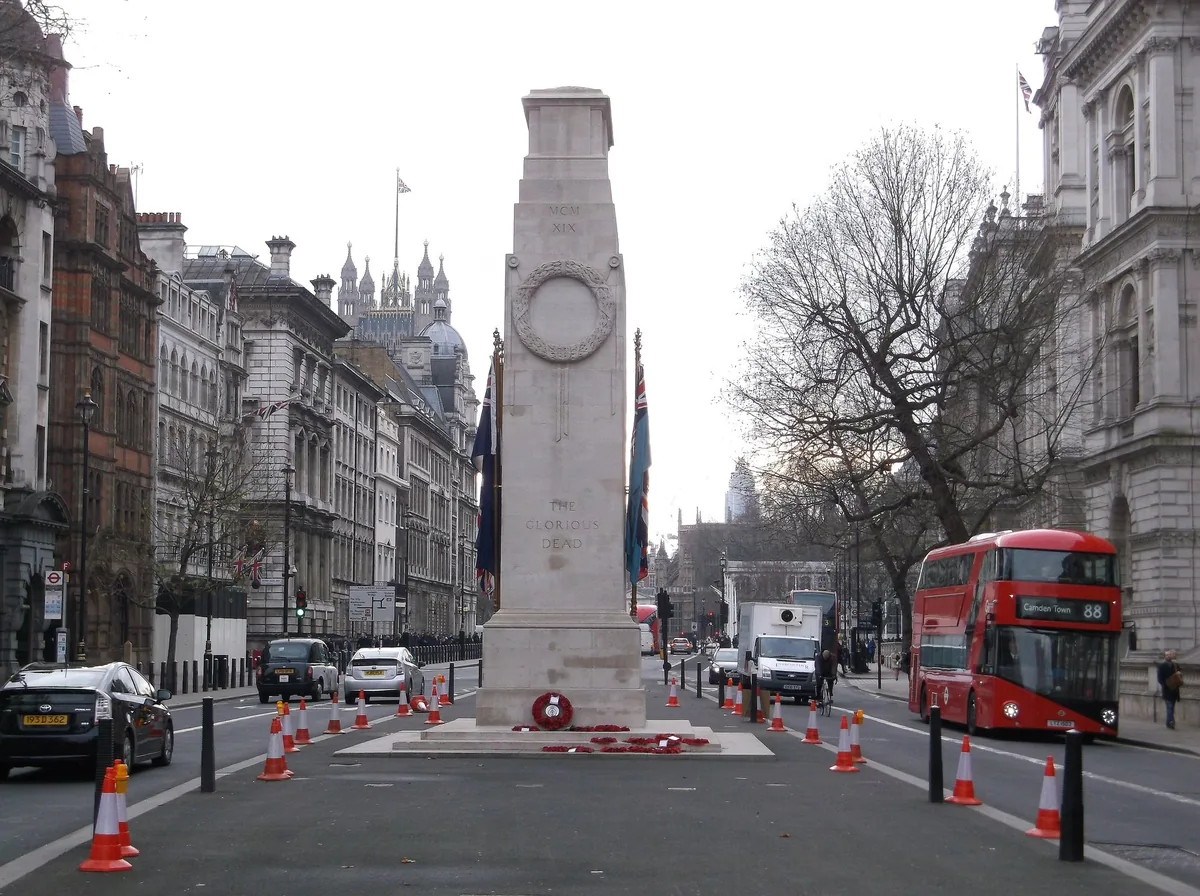 The Cenotaph standing in the middle of Whitehall, with poppy wreaths laid at its base