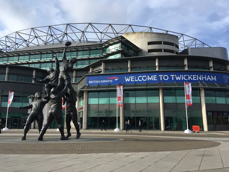The bronze lineout statue outside Twickenham Stadium, below a Welcome to Twickenham banner