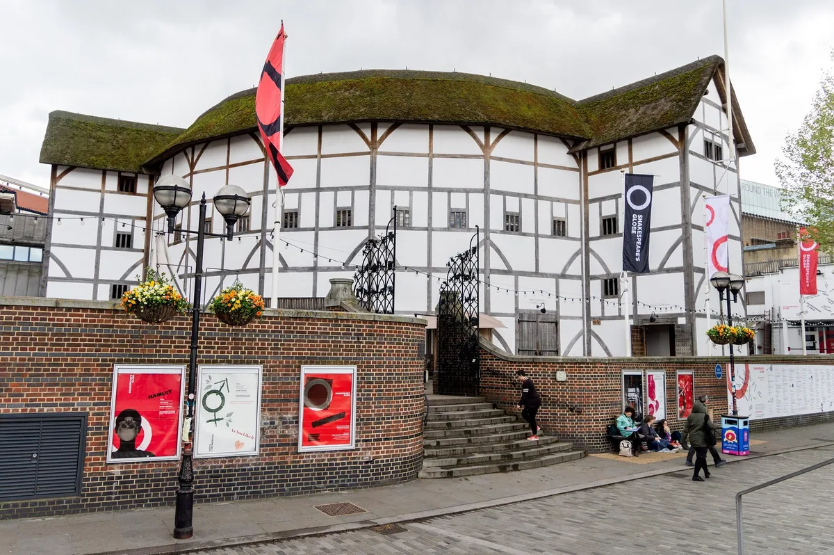 The timber-framed round playhouse of Shakespeare's Globe on Bankside, seen from the cobbled forecourt