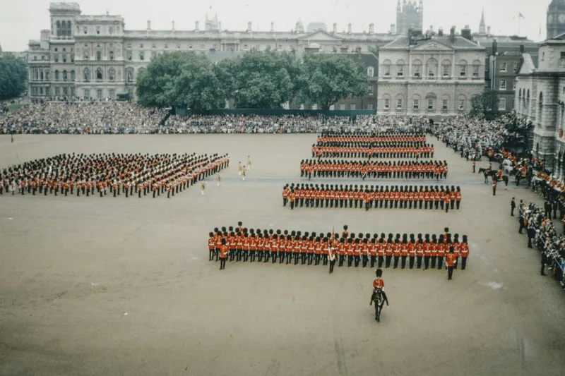 Massed ranks of guardsmen in formation across Horse Guards Parade with crowds lining the edges
