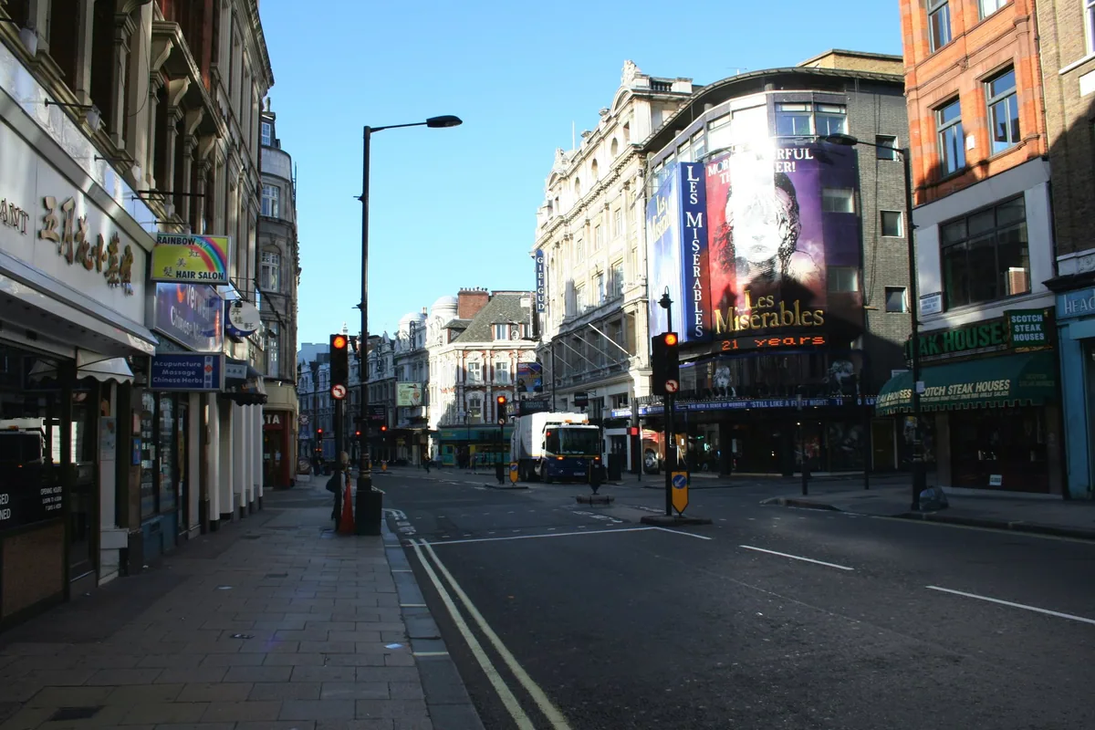 Shaftesbury Avenue in the West End early in the morning, with a theatre hoarding above the street
