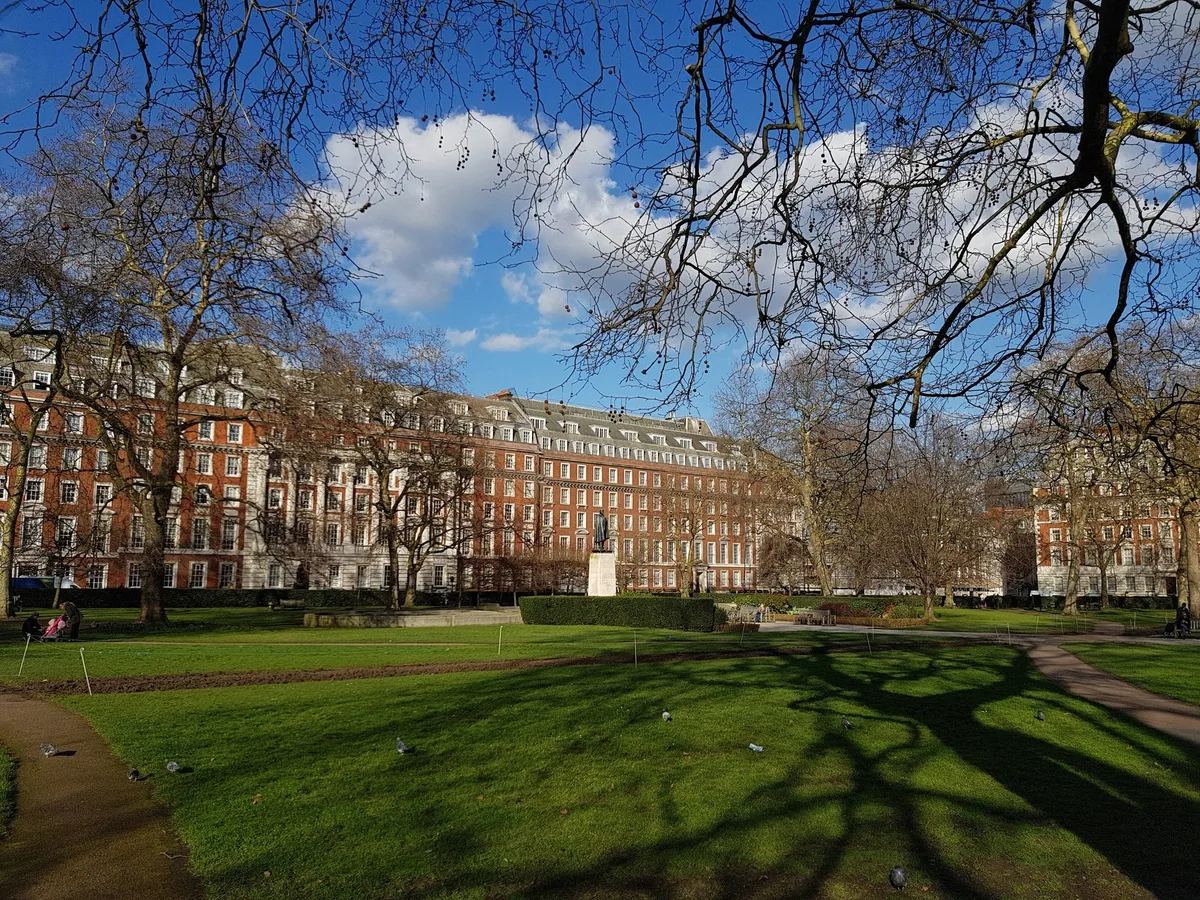 Grand brick and stone facades along the north side of Grosvenor Square in Mayfair