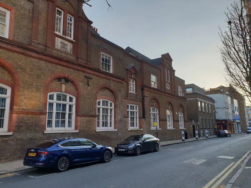 The long brick front of the former Bowling Green Lane board school in Clerkenwell, arched windows and gables above a quiet street