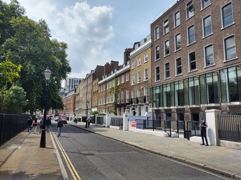 Georgian brick houses along the north-west corner of Lincoln's Inn Fields, with the railed gardens and plane trees opposite